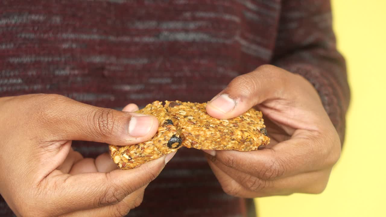 Una persona che tiene in mano una barretta di cereali