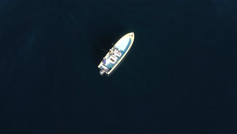 aerial perspective of angler hurriedly reeling in fish caught on bent rod