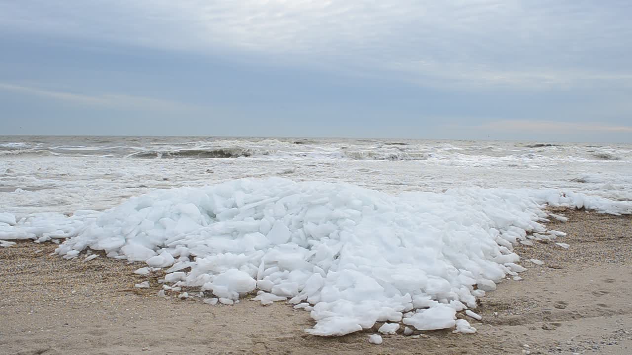 Isblock på en strand. Is och våg
