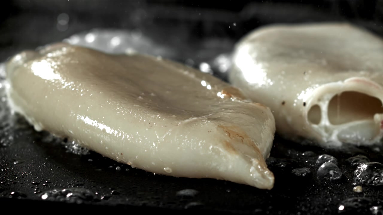 Calamars frais frits et grésillants dans une poêle chaude.