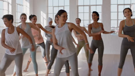 grupo de mujeres multiétnicas aprendiendo movimientos de baile disfrutando de un instructor de fitness enseñando coreografía de baile mostrando rutina divirtiéndose en el estudio