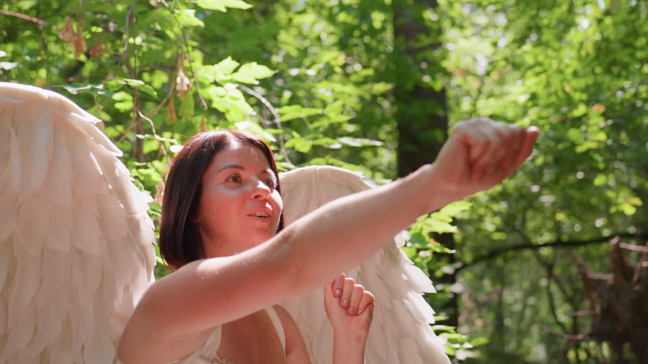 Goddess of love with angelic wings in white dress gently catches flies in sun dappled forest clearing, surrounded by lush greenery, radiating calm, curiosity, and other worldly grace