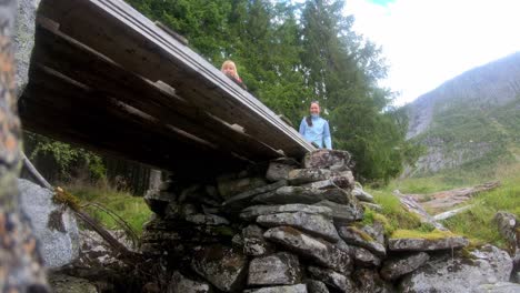 mum and daughter playing the goats roar outside in norwegian nature - low angle static under bridge while looking up at mum and daughter - wild forest background
