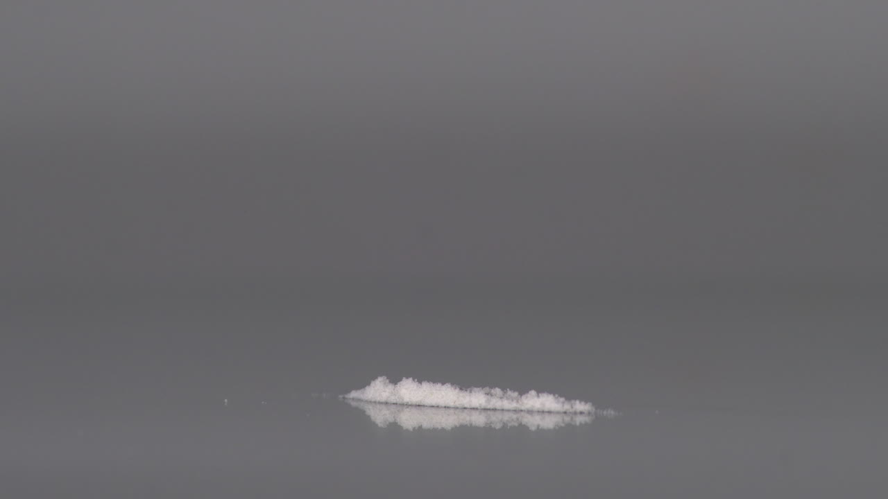 Inhaling a strip of heroin powder using rolled paper - close up