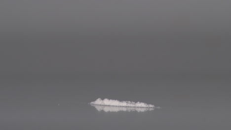 inhaling a strip of heroin powder using rolled paper - close up