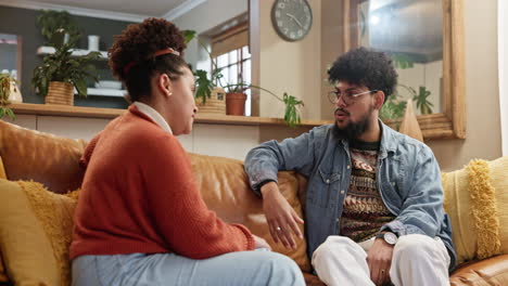 una pareja sentada en un sofá hablando
