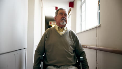 senior man in wheelchair in a hallway