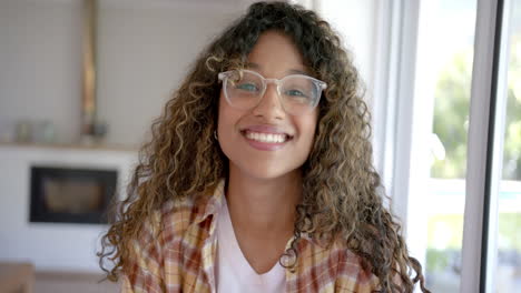 Retrato-De-Una-Feliz-Adolescente-Birracial-Con-El-Pelo-Rizado-En-Casa,-Cámara-Lenta