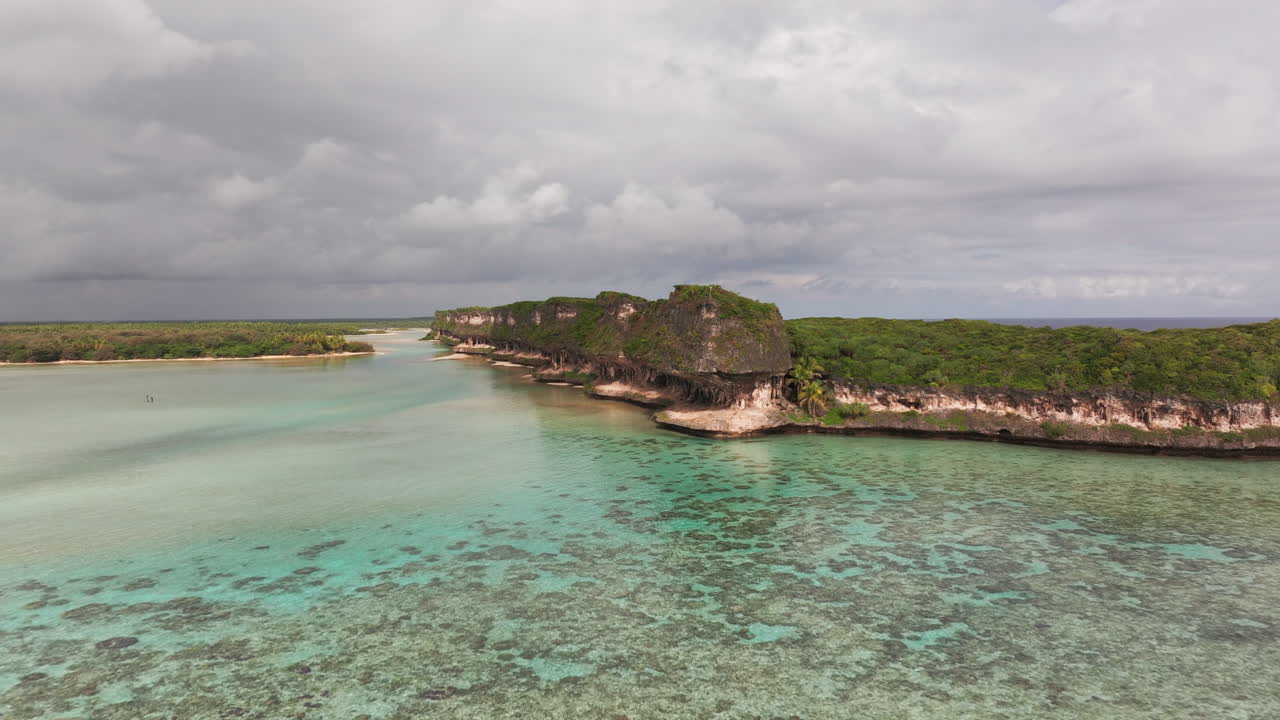 Filmato aereo con drone della baia di Lekini, Ouvéa, con enormi scogliere calcaree, acque turchesi della laguna, tratti di barriera corallina e paesaggio costiero tropicale in Nuova Caledonia