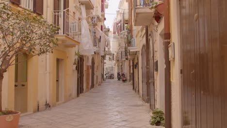 cobblestone street in the historical center of bari, italy with vespa