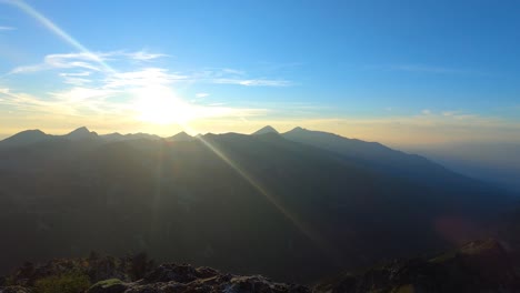 time lapse of sunset in the mountain. the setting sun colors the horizon in yellow, orange, red. sunbeams and clouds. summer in pirin.