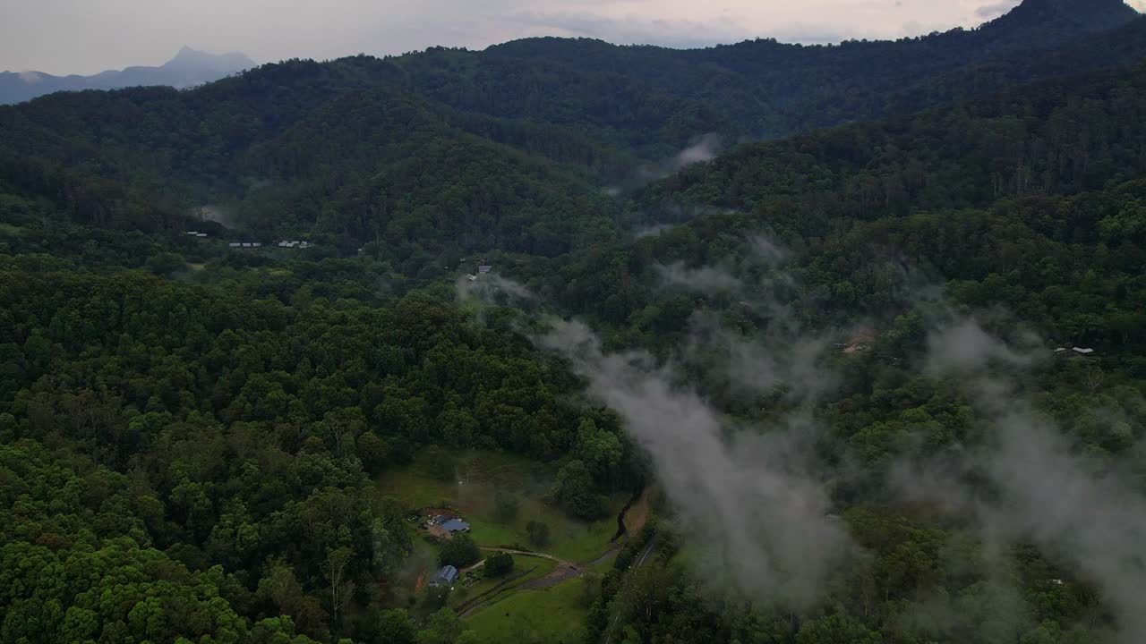 Hyperlapse di nuvole di nebbia sull'oasi serena della Currumbin Valley nell'entroterra di Gold Coast, con rigogliosa foresta pluviale e paesaggio rurale