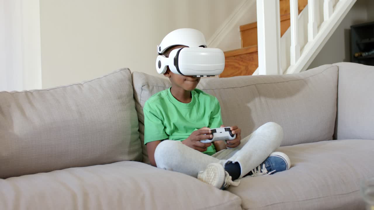 VR game is starting, causing child to manipulate white controller while wearing headset on couch