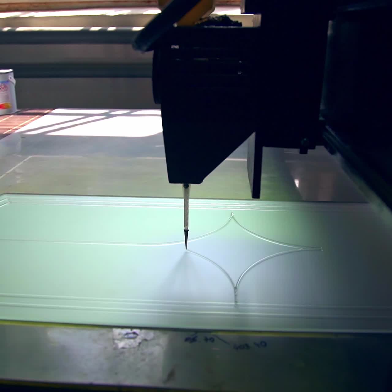 Thin applicator of automatic machine draws lines on the glass. Door décor at the modern door production