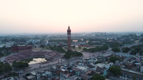 breathtaking aerial capture of lucknow's clock tower at dawn, with the surrounding buildings lit by the soft glow.