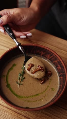 mujer comiendo una sopa de setas cremosa