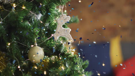 animation of confetti falling over christmas tree with baubles