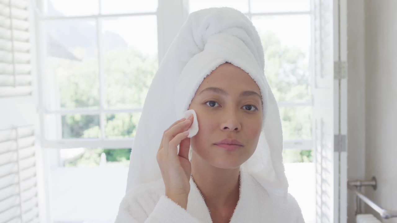 행복한 아시아 여성이 화장실에서 피부를 청소하고, 느린 동작으로