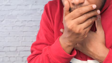 man covering his mouth and chest