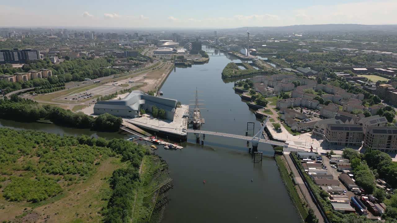 High aerial static of the River Clyde, Riverside Museum and Govan footbridge with Glasgow city skyline in distance, Glasgow, Scotland, UK