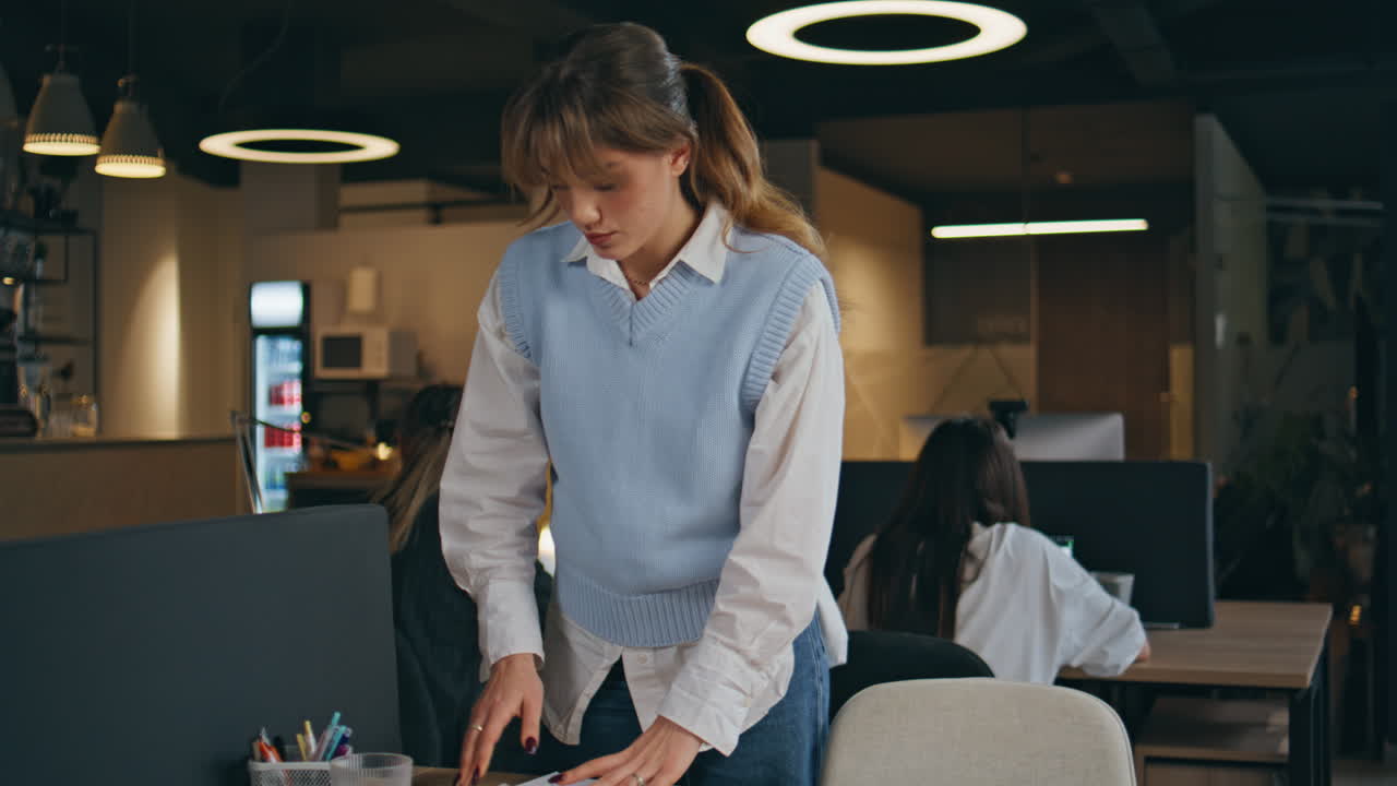 Designer d'interni che prepara lo spazio di lavoro per lavorare in un open space. Donna che riordina la scrivania