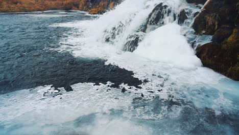 Agua-Moviéndose-Bajo-El-Hielo-De-La-Corriente-De-Cascada-En-Islandia
