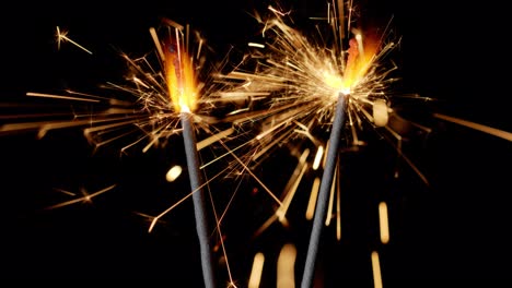 Bengal-fires,-New-Year-sparkler-candles,-sparkling-lights-burning-on-a-black-background,-slow-motion