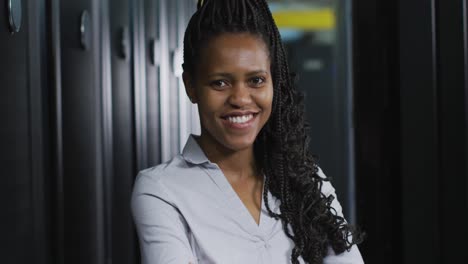 african american female computer technician with security pass in business server room