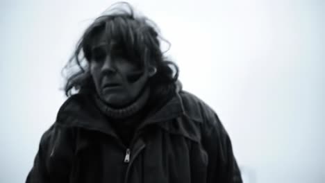 an elderly woman moves slowly in a dimly lit area, her expression reflecting contemplation and weariness. the environment adds an air of introspection to this poignant moment.
