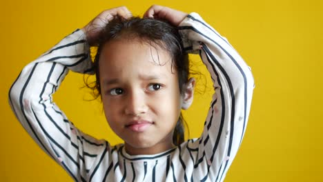 sad upset child girl crying against yellow background