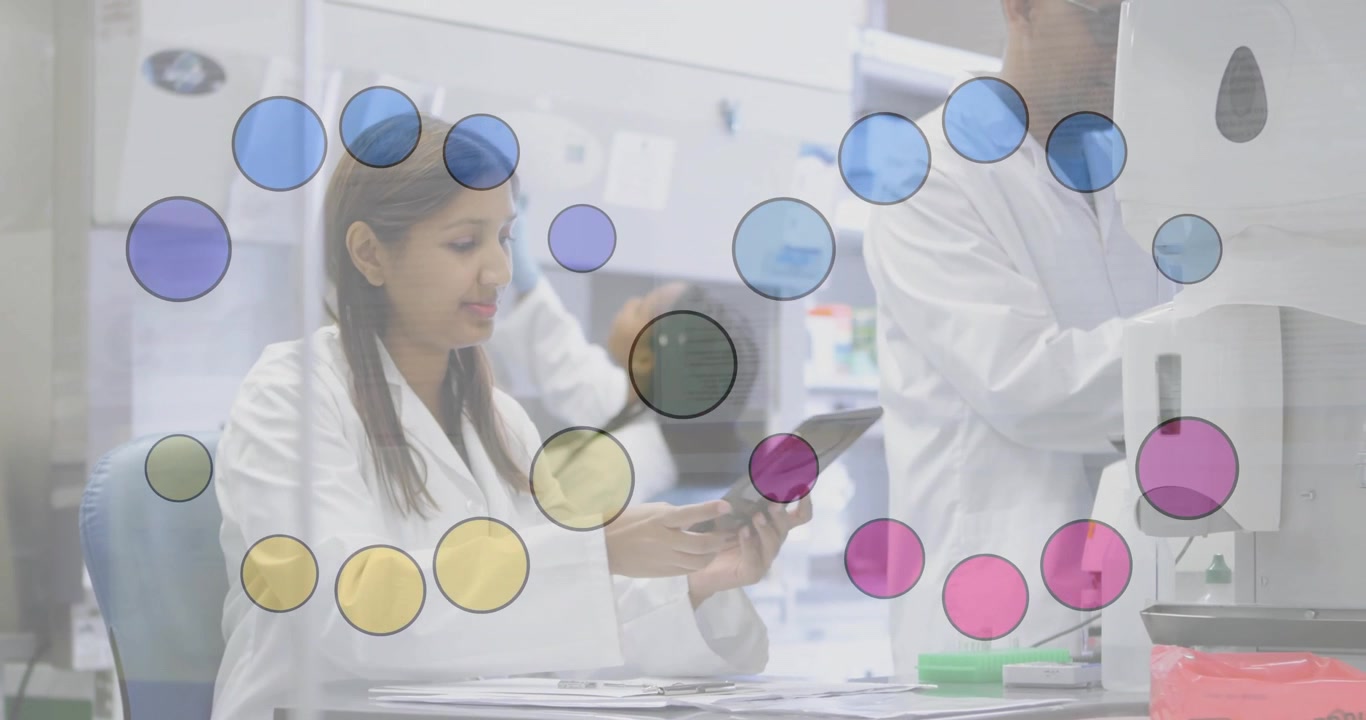 Técnica de laboratorio india organizando portaobjetos y luego tocando una tableta que muestra datos en un laboratorio de investigación.