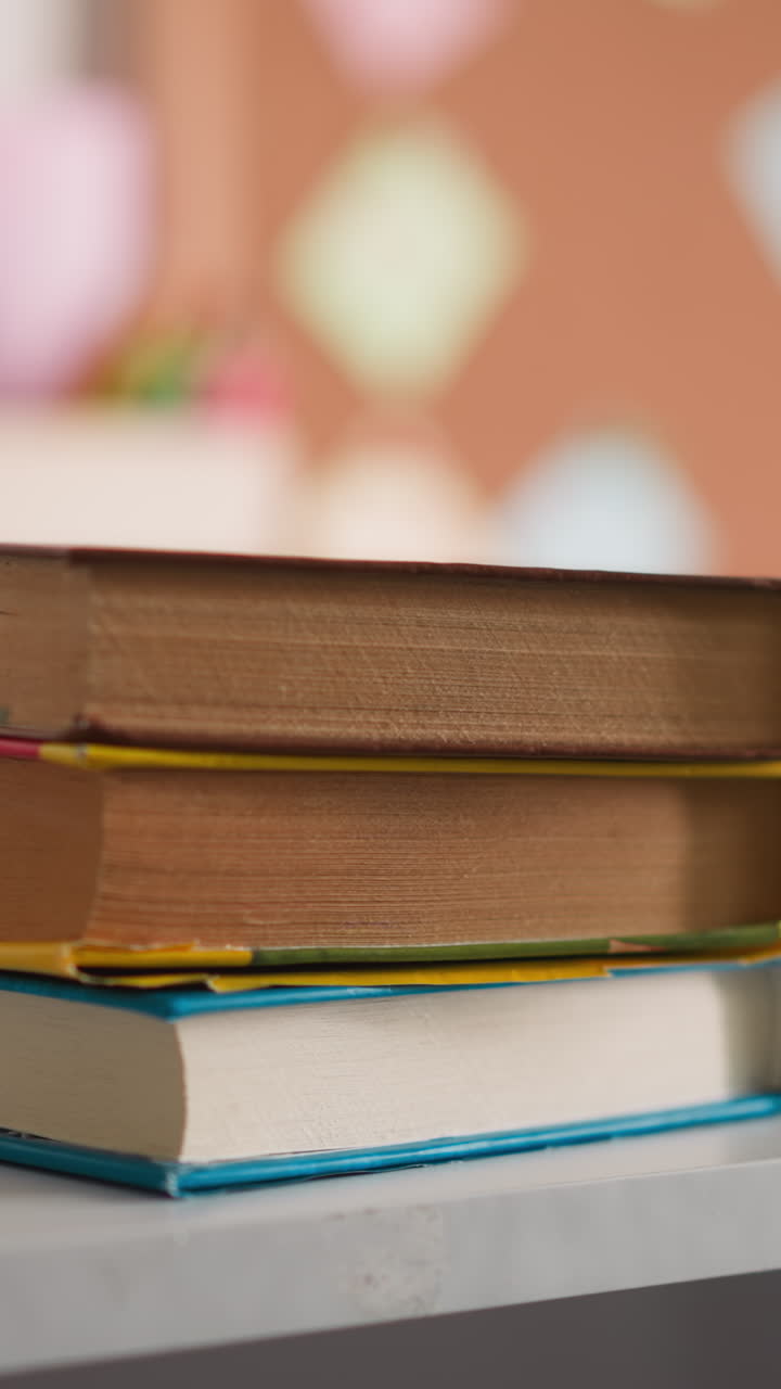 Girl student puts textbooks stack near open copybook on desk with supplies at home closeup. Schoolgirl ready to do homework tasks at table in room