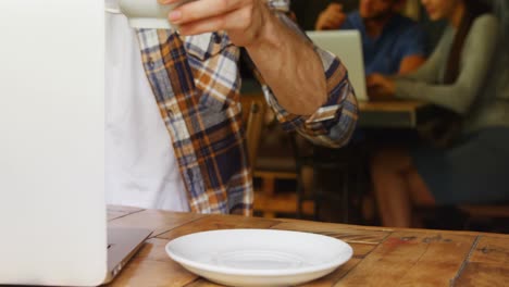 hombre tomando café mientras usa una computadora portátil en un café 4k