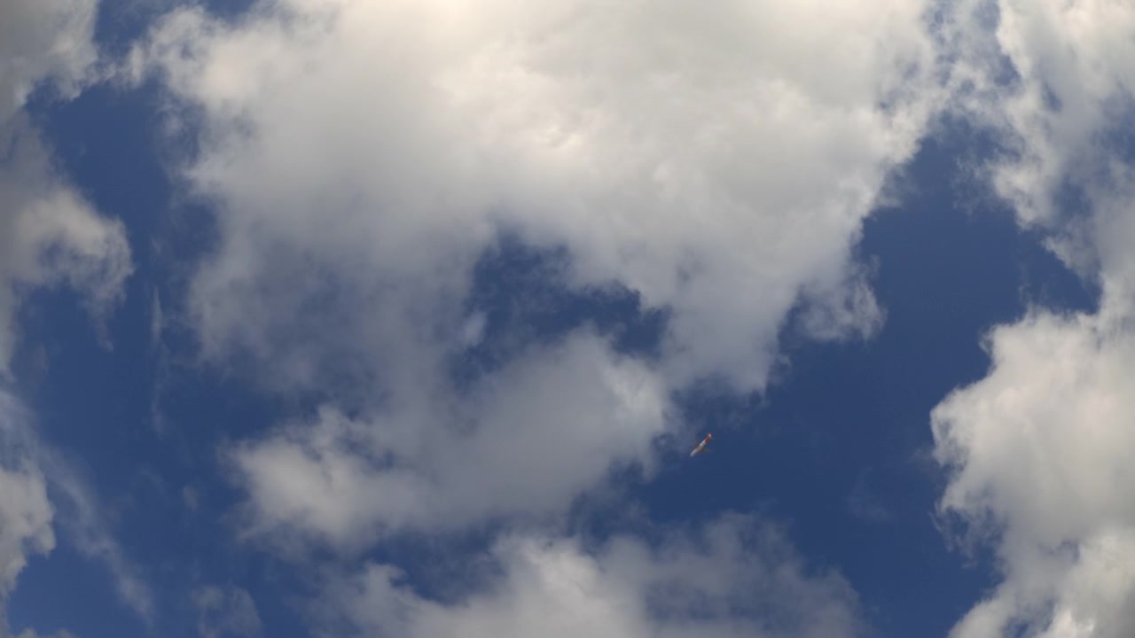 Low-angle view of a blue sky with scattered white clouds