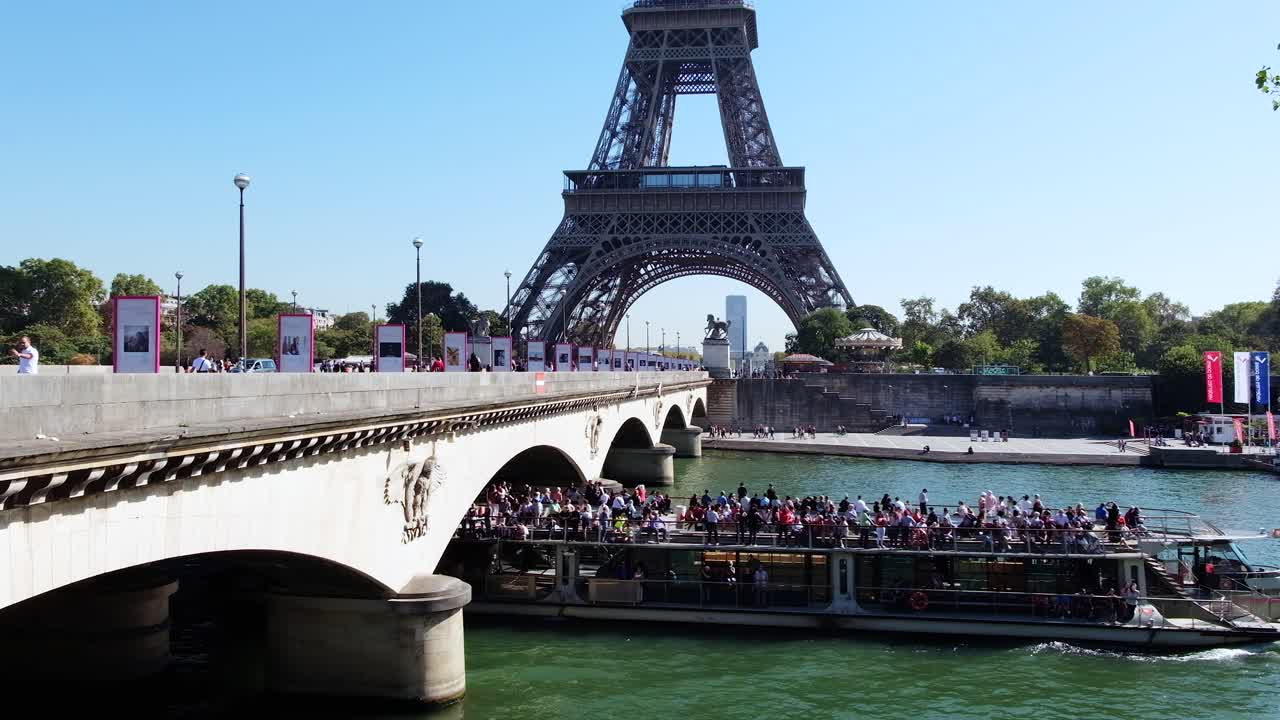 Paris, France - April 18, 2021: A boat full of people moving on the Seine, under the Pont d'Iena