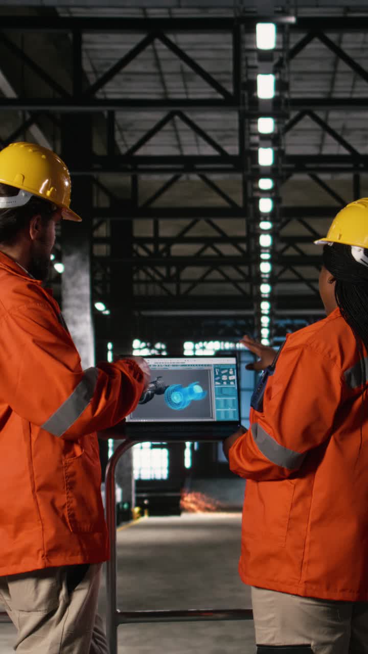 Vertical Video Engineering team review gas turbine software on laptop in large-scale factory