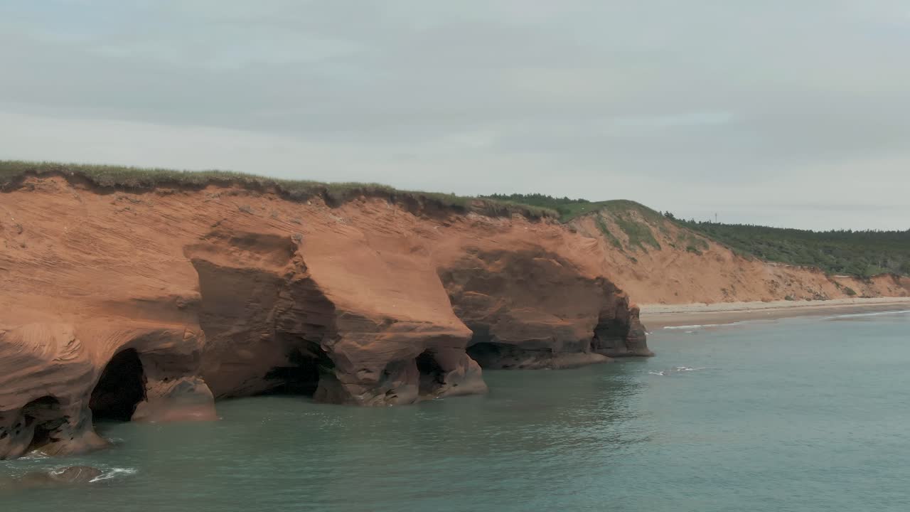 Aerial reveal view of ocean rock caves and formations on Magdalen Island coast