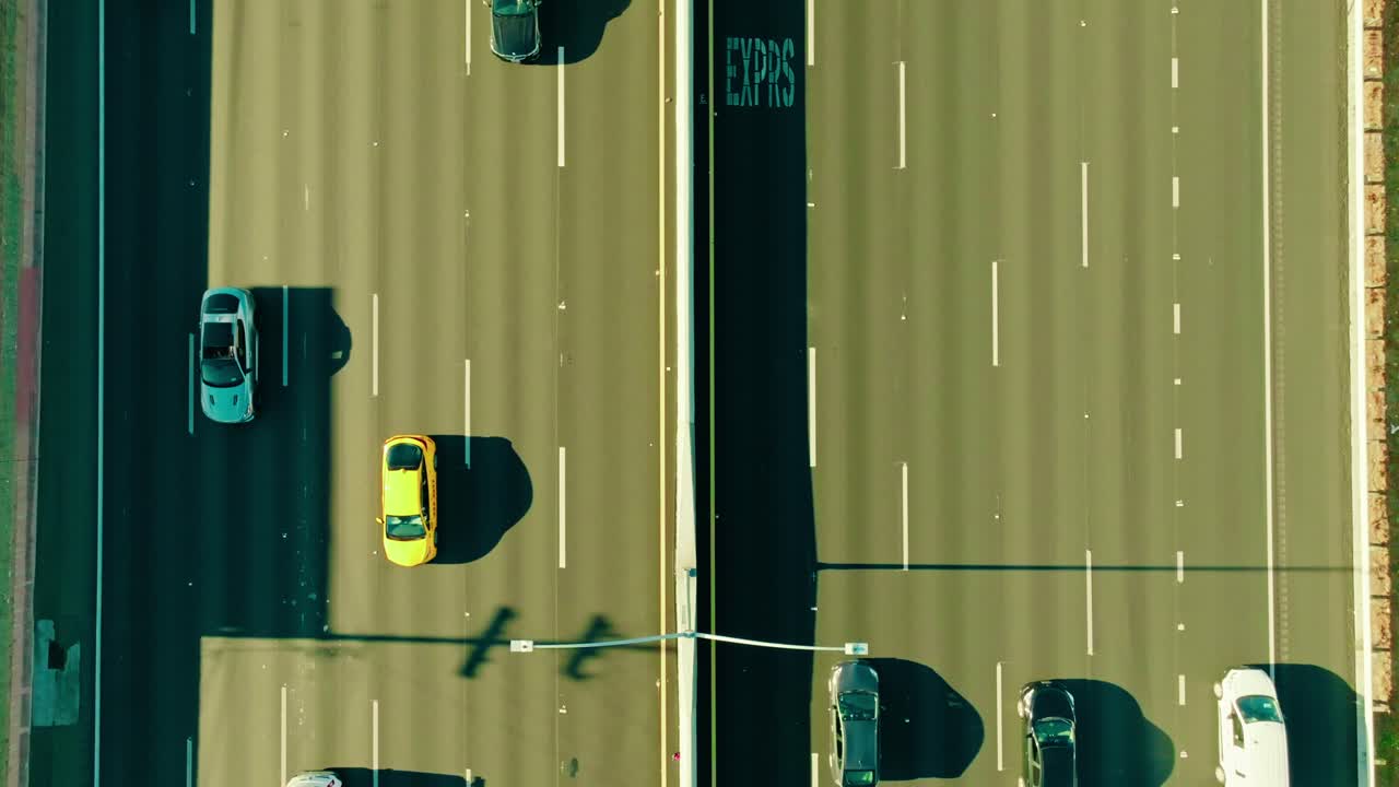 Bird's-eye aerial view unveils the dynamic movement of cart traffic along a sunlit highway