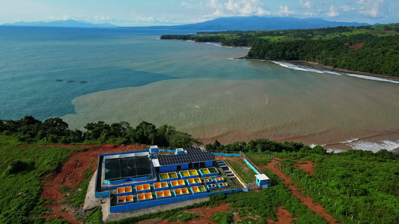 Pull‑out aerial of Nagbayog View Deck in Mariveles, Bataan, showing striking contrast between blue and brown coastal waters as the drone rises above the nearby power plant