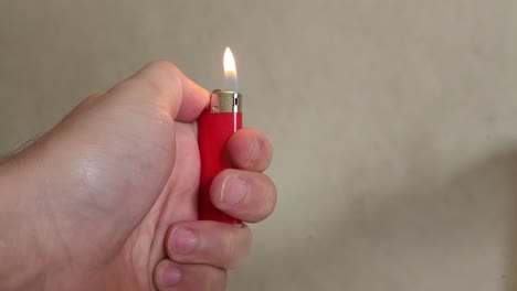 video de una mano que enciende un pequeño encendedor rojo y luego deja que la llama se apague