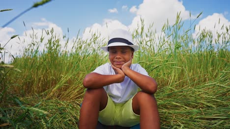 a boy sitting in a wheat field