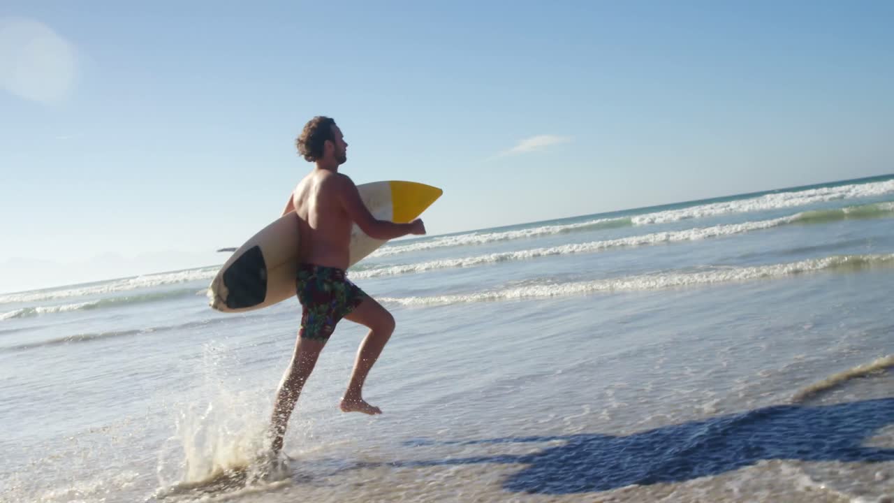 Uomo che corre con la tavola da surf in spiaggia
