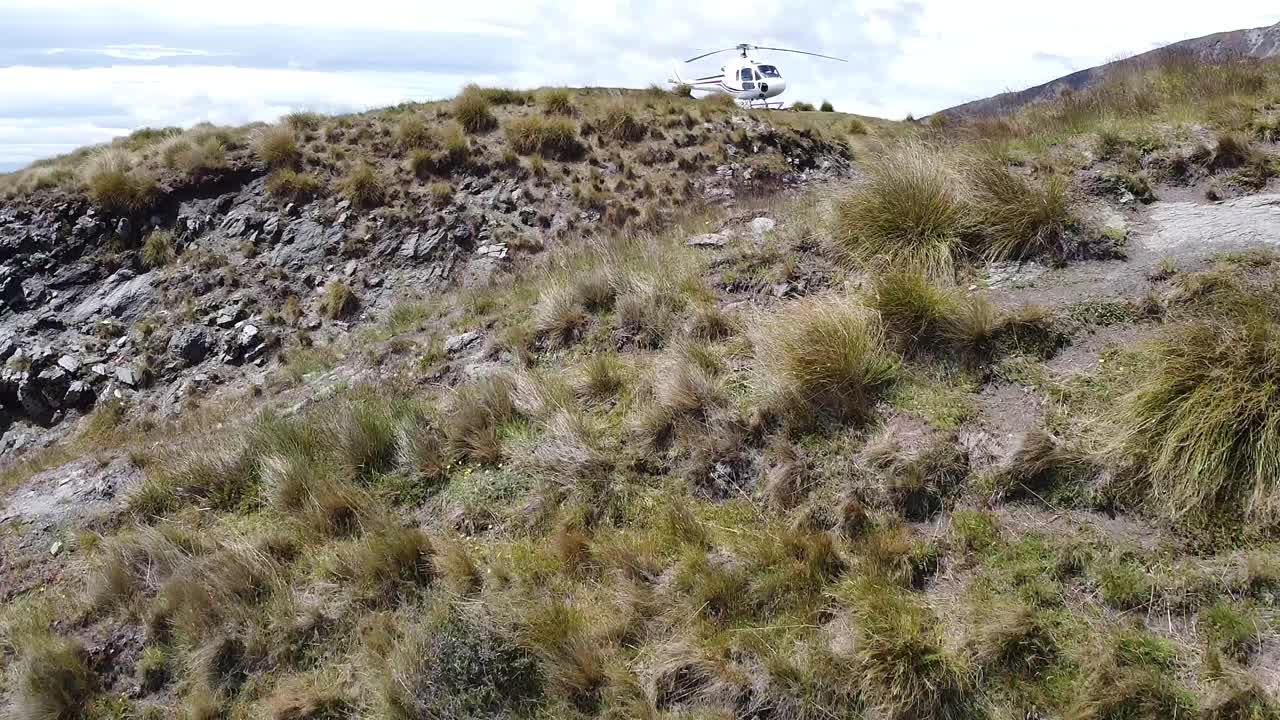 volando hacia un helicóptero en la hierba de otoño de montaña
