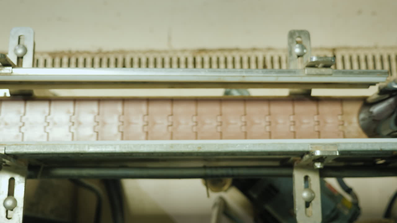 코르크 스토퍼로 닫힌 와인 병은 위에서 컨베이어 벨트 보기를 따라 이동합니다.