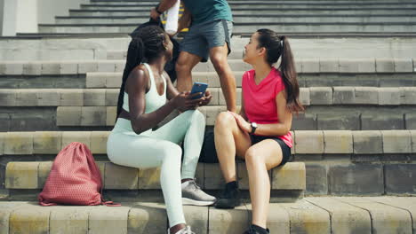dos atletas femeninas usando un teléfono