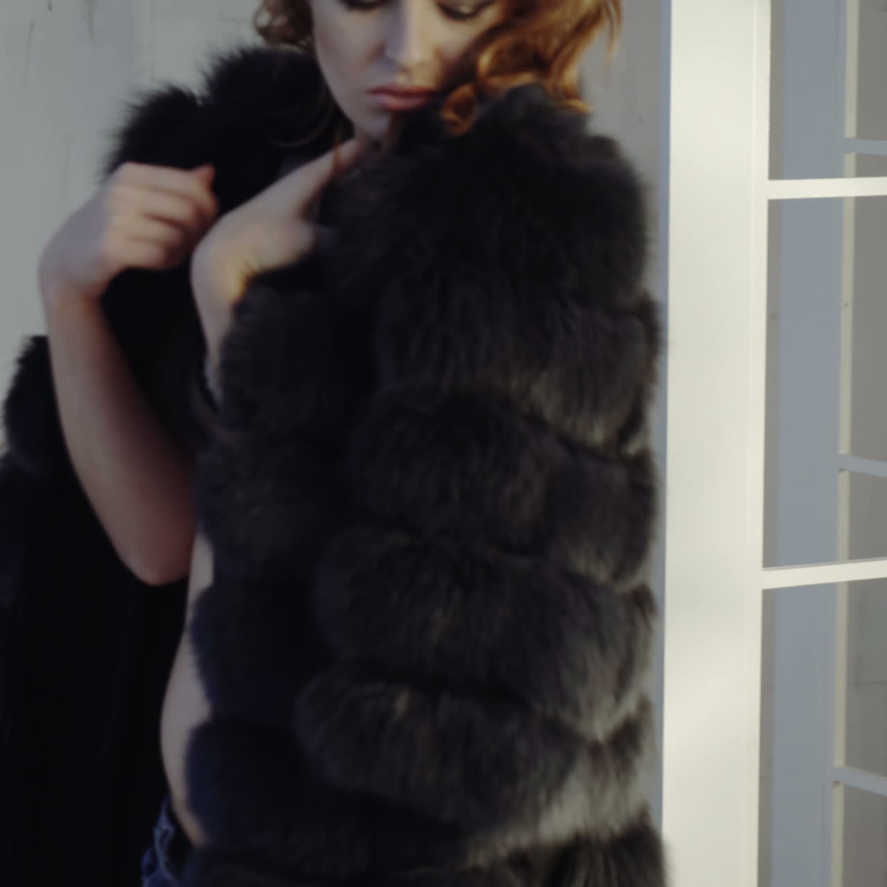 A young sexy woman takes off her coat and remains in her underwear.