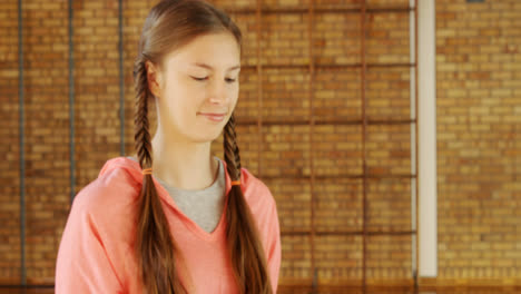 high school girl standing with basketball in the court