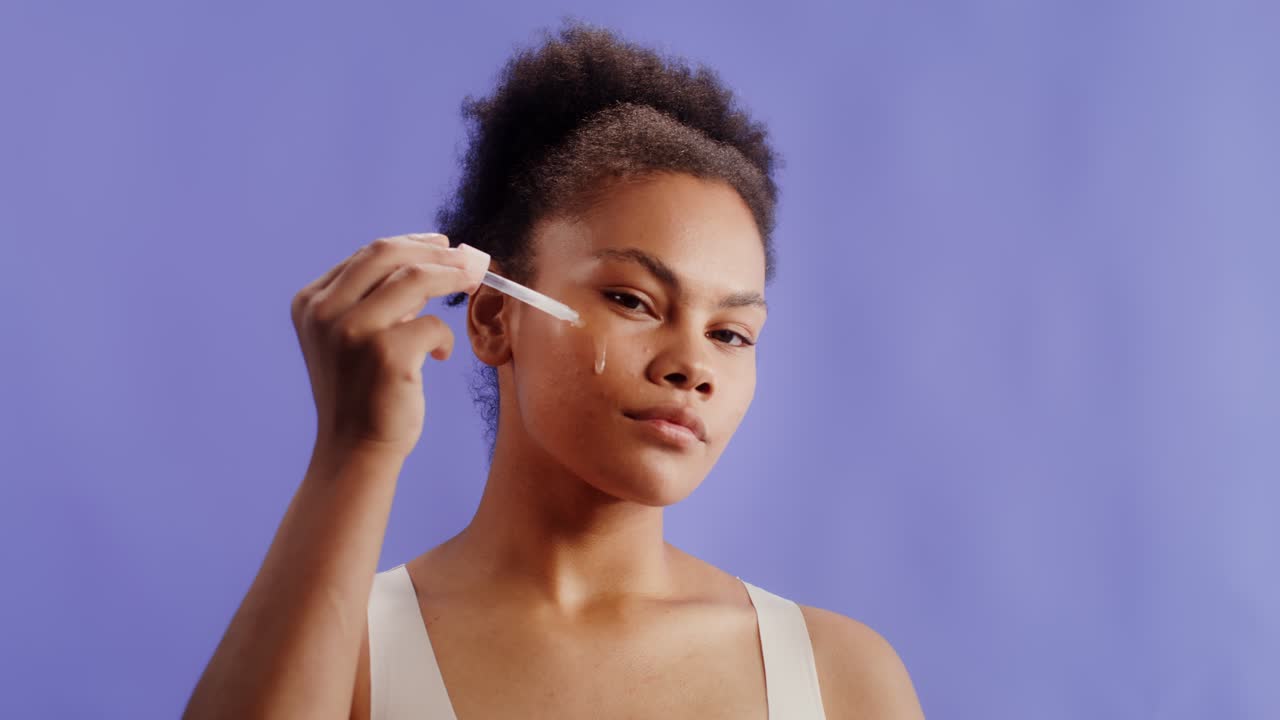 mujer aplicando suero a la cara