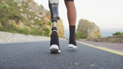 sporty mixed race man with prosthetic leg hiking