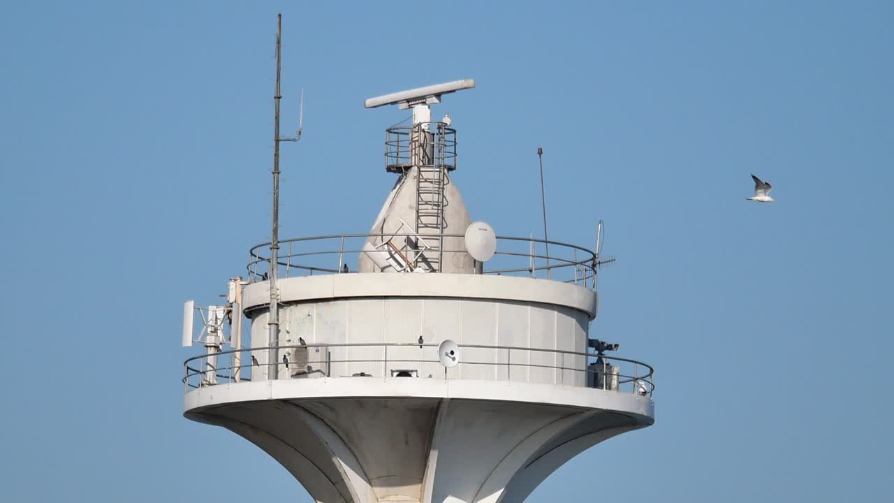 Top of a white observation tower with communication equipment